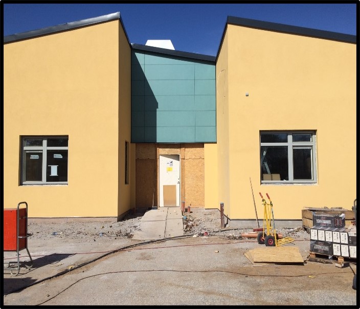 Pilevallskolan i Trellebrog, utvändigt foto under byggtiden, Gul fasad med gröna detaljer