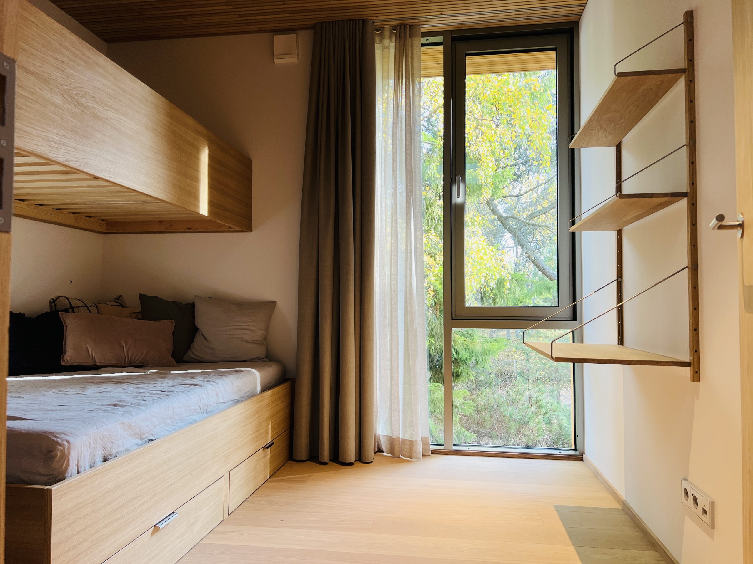Sovrum med platsbyggda sängar i två våningar och inredning samt string hyllor