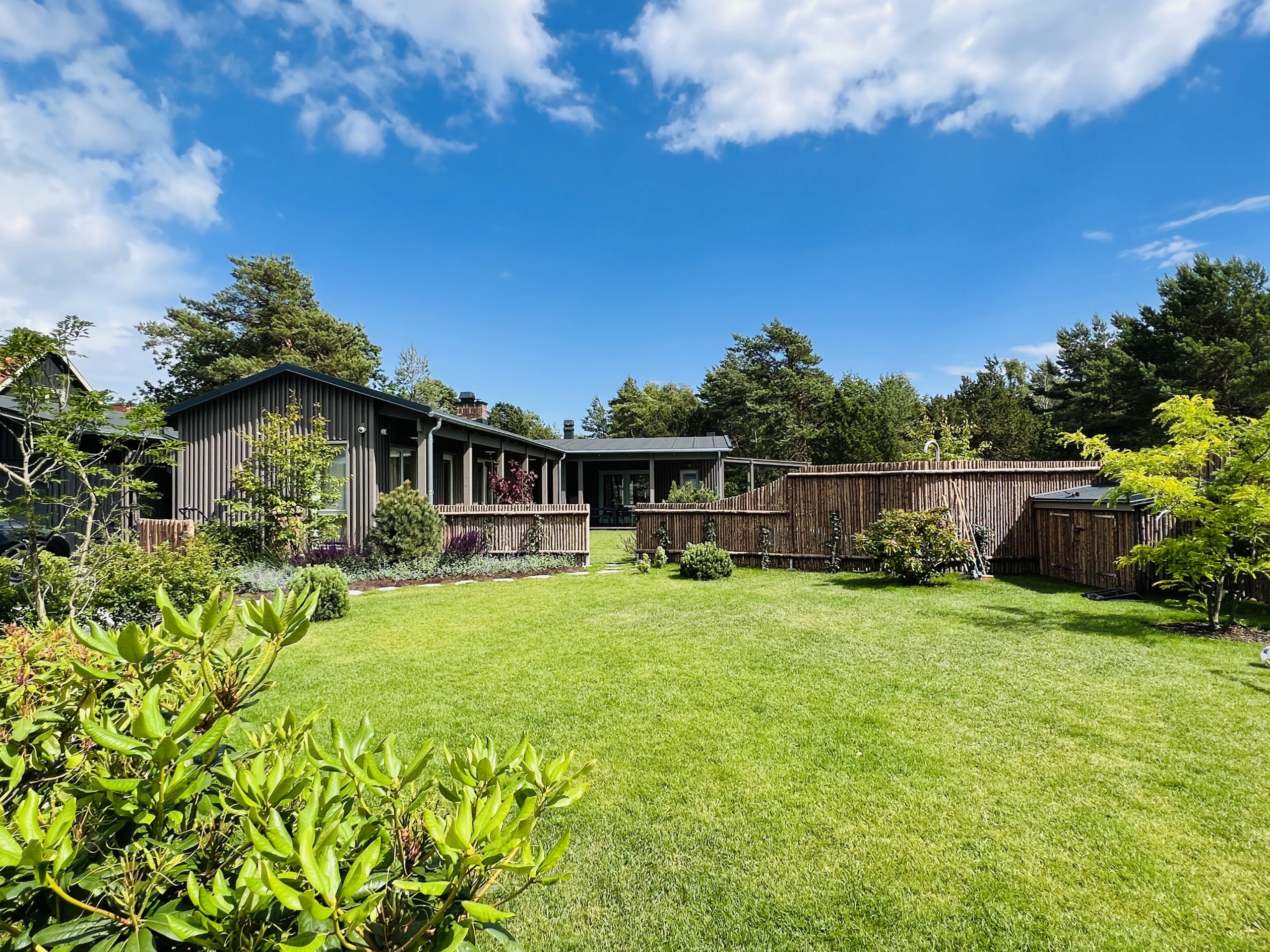 Nyrullat gräs, granslanor, arkitektritat fritidshus i täpanelmed pool, relaxavdelning, utedusch och utekök i Falsterbo
