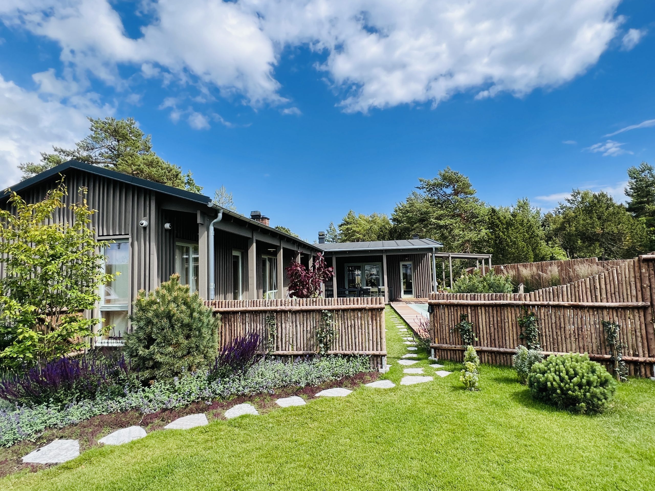 Nyrullat gräs, granslanor, arkitektritat fritidshus i täpanelmed pool, relaxavdelning, utedusch och utekök i Falsterbo