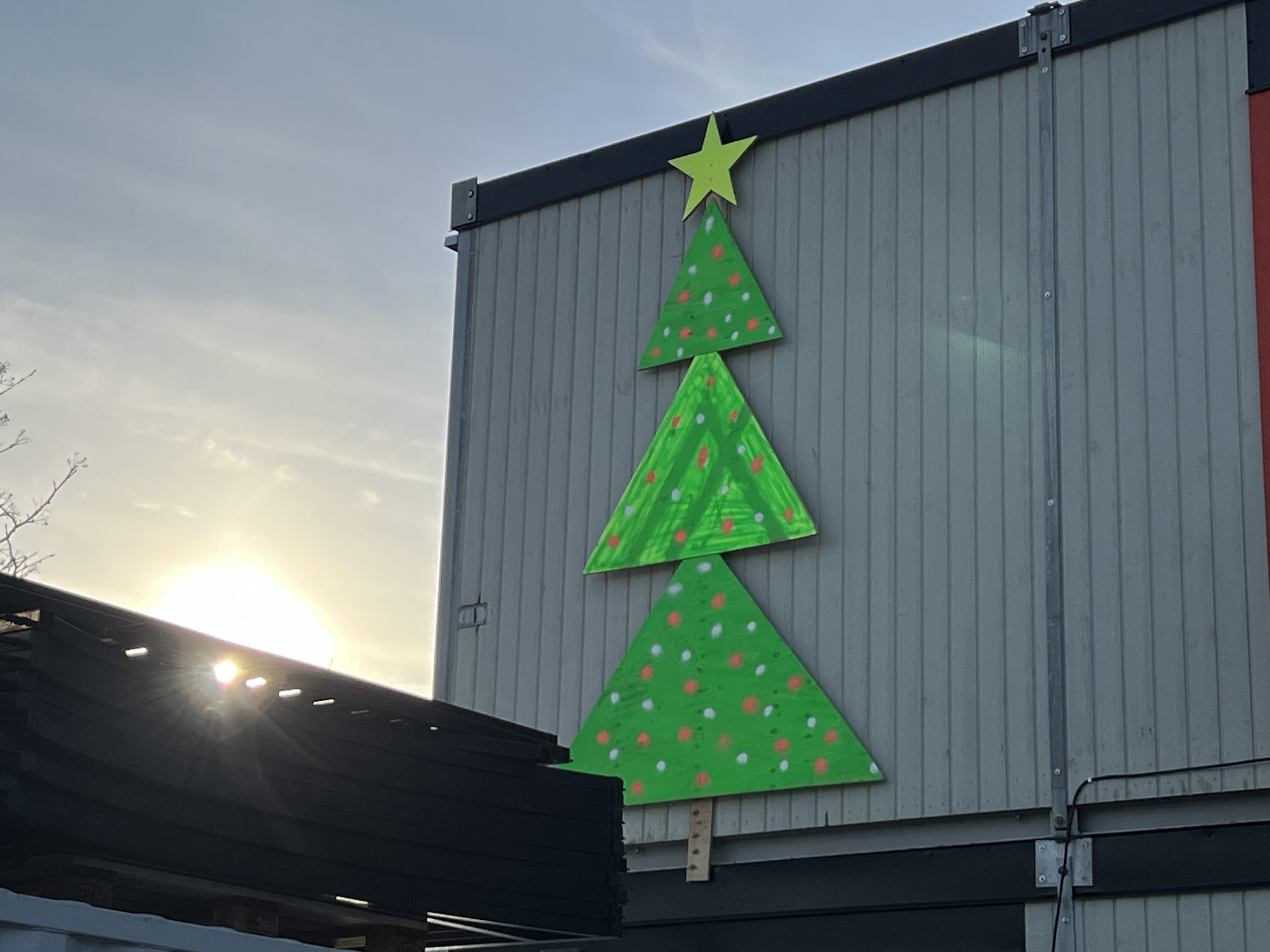 Byggboden är utsmyckad med en julgran i grön färg med kulörta kulor och en guldig stjärna