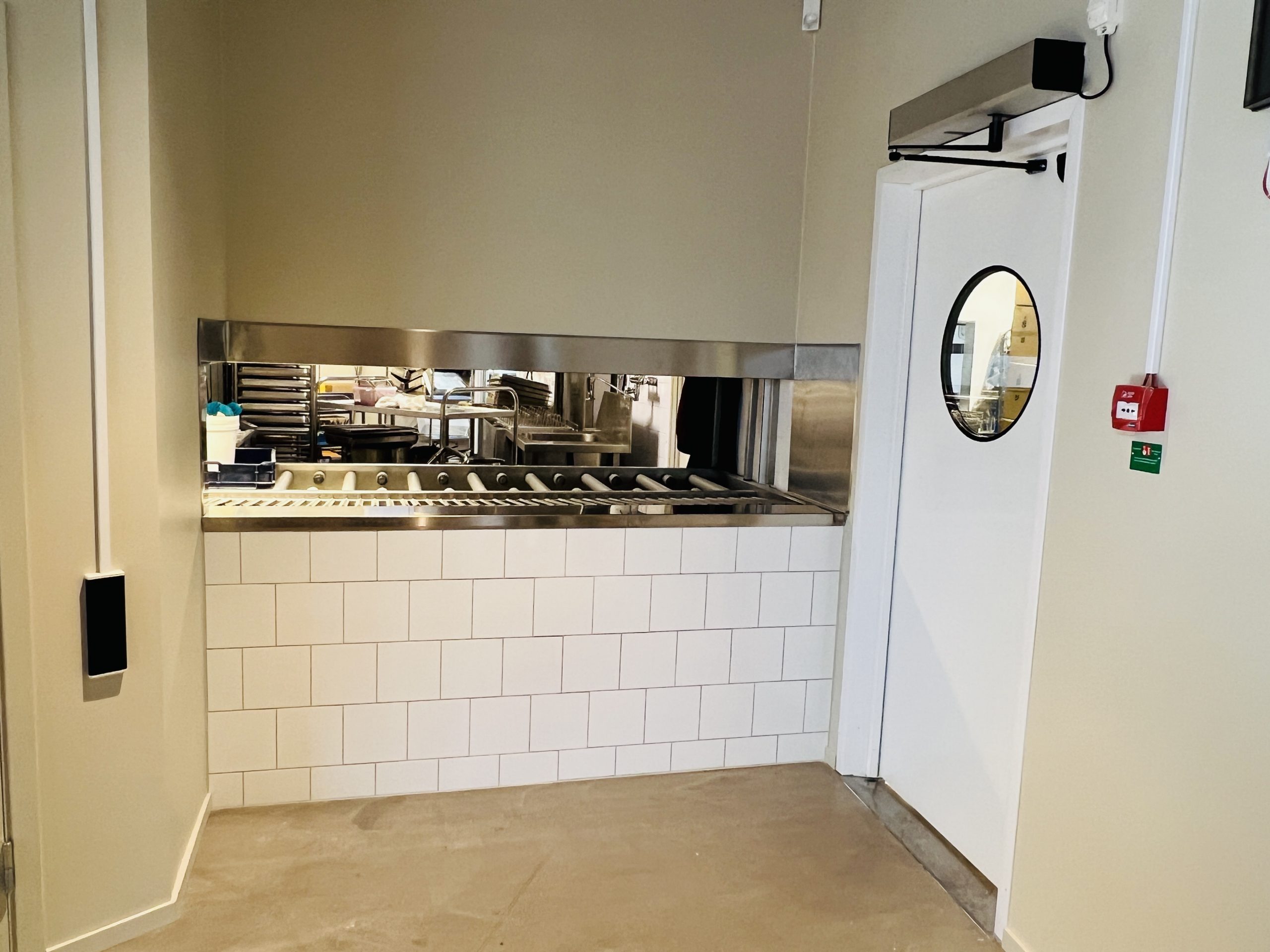 Ny köksdörr till restaurangen. Vit dörr med runt fönster i man ser även luckan från köket där maten levereras