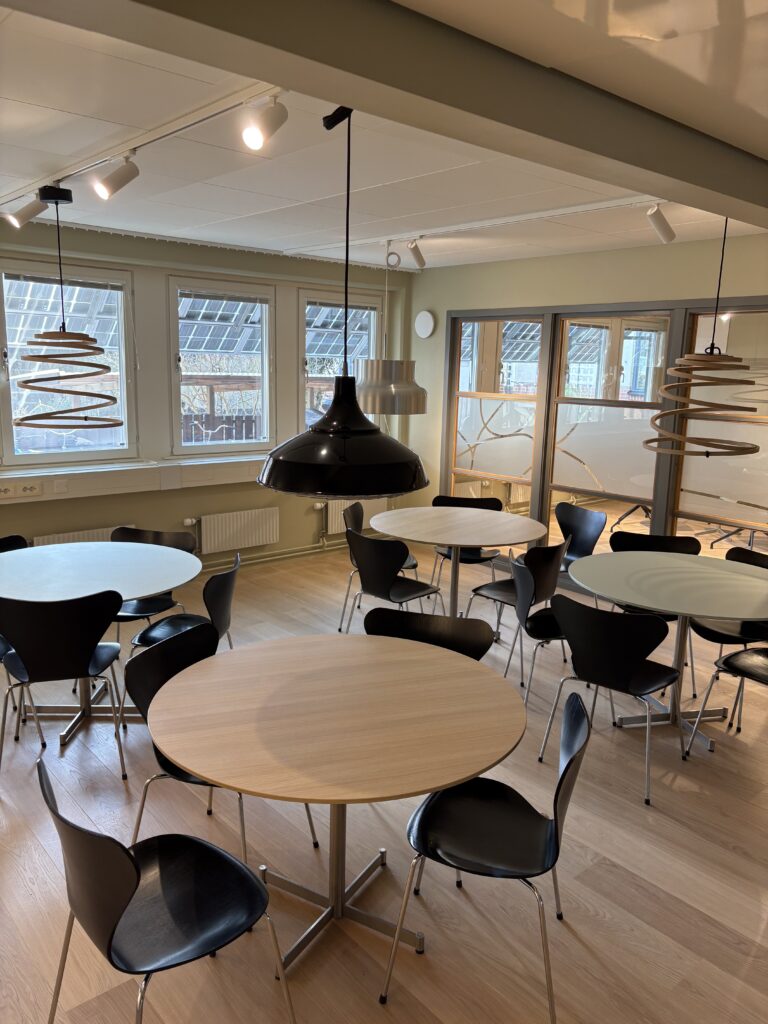 ny och rymlig personalmatsal. Den nya matsalen erbjuder nu förbättrade möjligheter att både värma medhavd mat och ta med inköpt mat från restaurangen i huset. Runda ekbord med bekväma svarta stolar och taklampor över varje bord