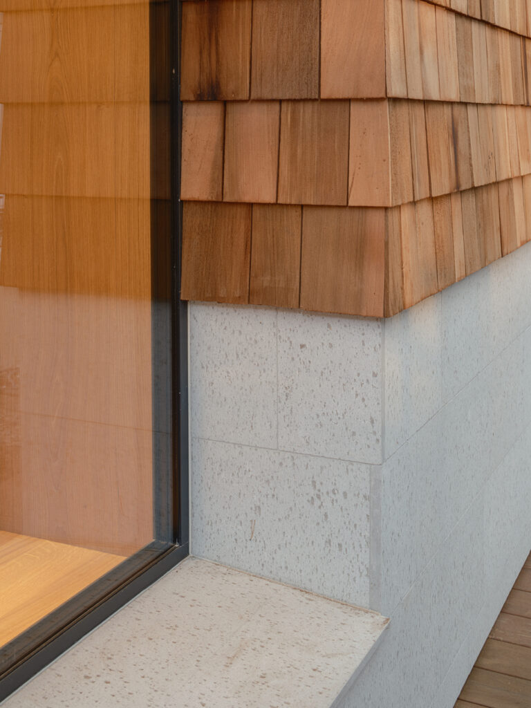 Exteriör av Villa P2 i Höllviken – en arkitektritad villa från Sawi Exclusive Homes by Treano, omgiven av tallar och ljung. Den moderna fasaden, harmonisk belysning och naturliga material framhäver husets exklusiva design och miljöklassificering 1.0.